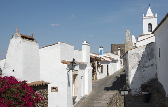 street with white houses and church in monsaraz in alentejo portugal