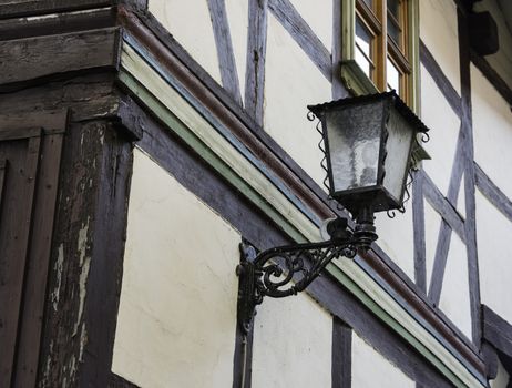 old vintage antique lamp at half timbered house typical for germany with white plaster and wooden beams