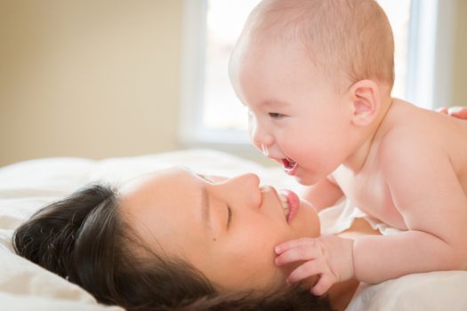 Young Mixed Race Chinese and Caucasian Baby Boy Laying In His Bed with His Mother.