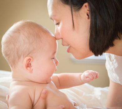 Young Mixed Race Chinese and Caucasian Baby Boy Laying In His Bed with His Mother.