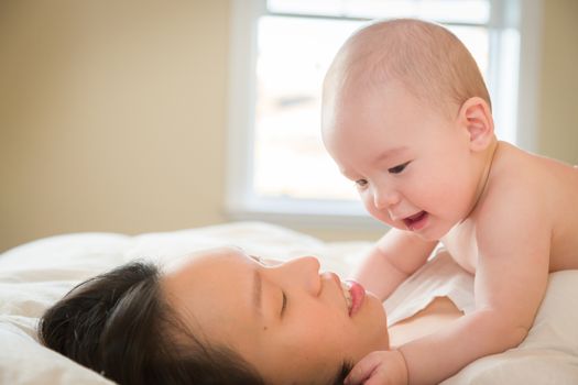 Young Mixed Race Chinese and Caucasian Baby Boy Laying In His Bed with His Mother.