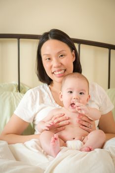 Young Mixed Race Chinese and Caucasian Baby Boy Laying In His Bed with His Mother.