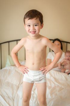 Young Mixed Race Chinese and Caucasian Boy Jumping In Bed with His Family.