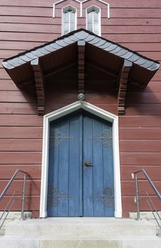 old church entrance with blue door in red wooden building