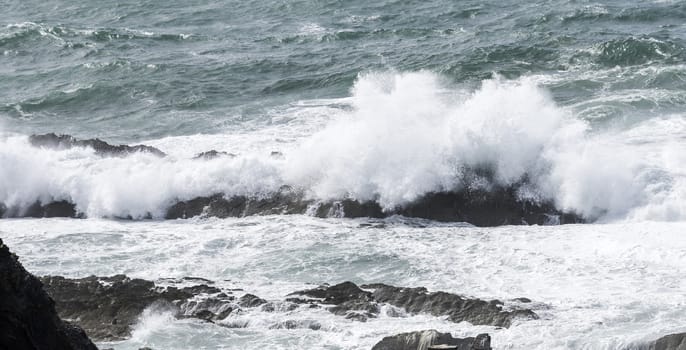 big waves splashes over the rocks in the ocean