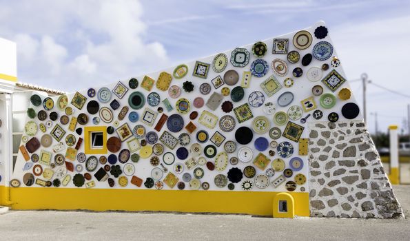 Typical Portuguese ceramics in red green yellow on white wall in sagres Portugal