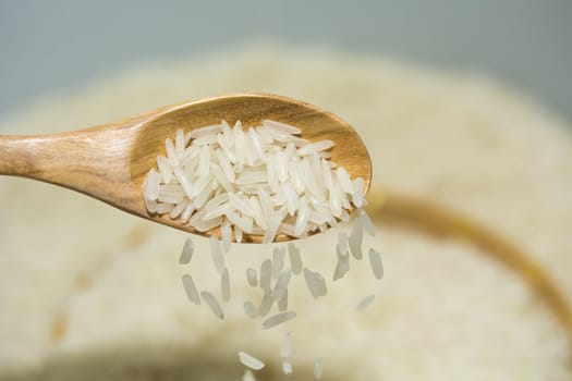 Pouring thai jasmine rice from wooden spoon