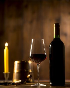 Pouring red wine into wineglass from green bottle, brown background