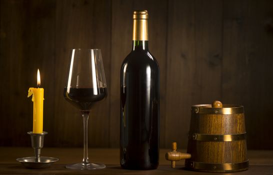Pouring red wine into wineglass from green bottle, brown background