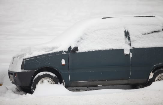 small car under a thick layer of snow