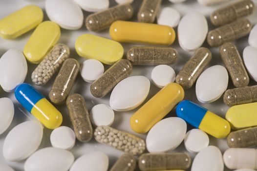 Colored pills, tablets and capsules on a white background