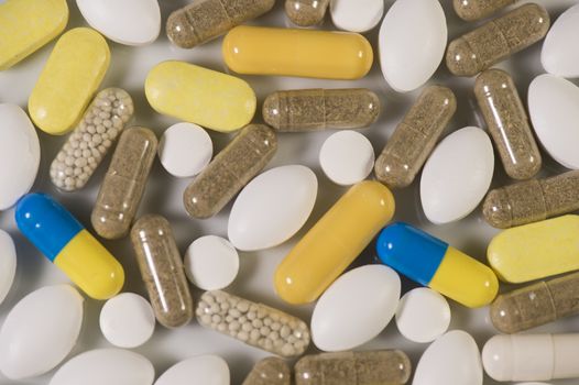 Colored pills, tablets and capsules on a white background