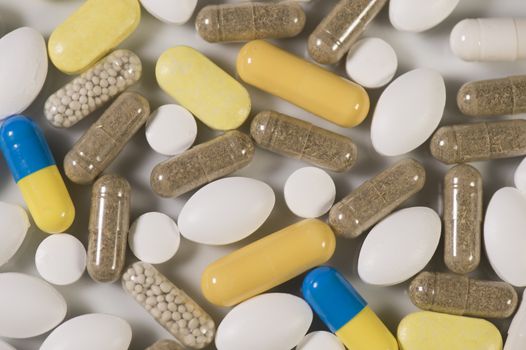 Colored pills, tablets and capsules on a white background
