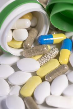 Colored pills, tablets and capsules on a white background