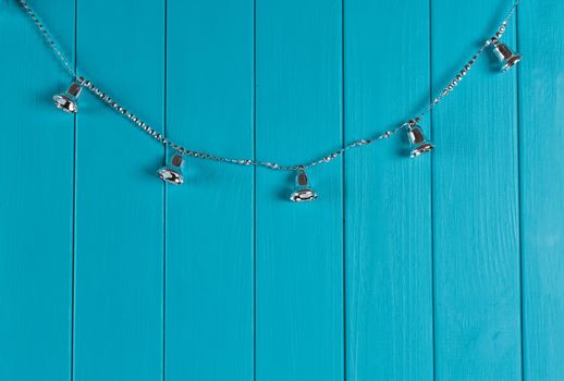 Christmas silver bell on blue wall. Copy space in right side