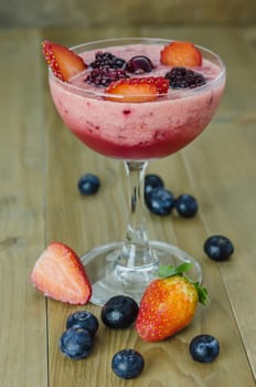 Raspberry smoothie with fresh berries on a wooden table