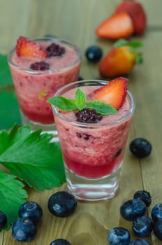 Raspberry smoothie with fresh berries on a wooden table