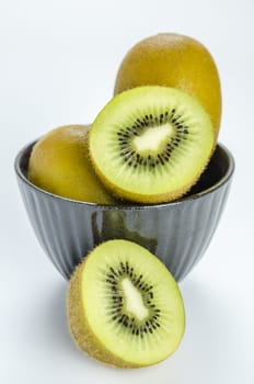 kiwi fruit and half with black bowl on white background