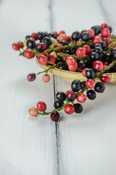 Thai Blueberry in bamboo basket over wooden background