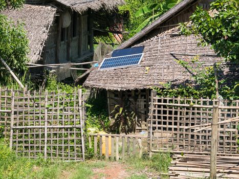 Straw house with solar panel on the roof in a village at the Rakhine State of Myanmar.