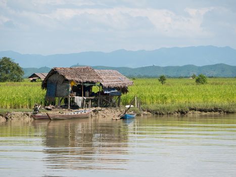 Traditional farmhouses made from straw along the Kaladan River in the Rakhine State of Myanmar.