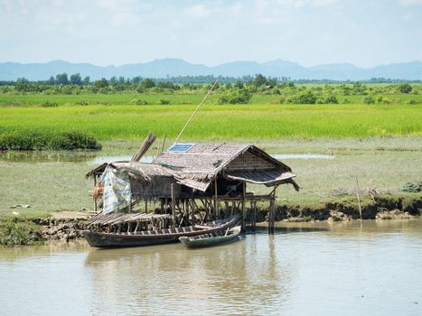 Very simple, traditional farmhouse made from straw, but with a solar panel on the roof for electricity, along the Kaladan River in the Rakhine State of Myanmar.