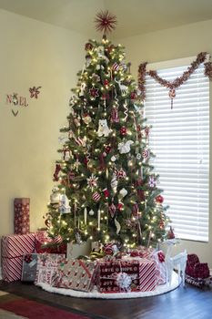 Beautifully decorated Christmas tree with gifts inside new home