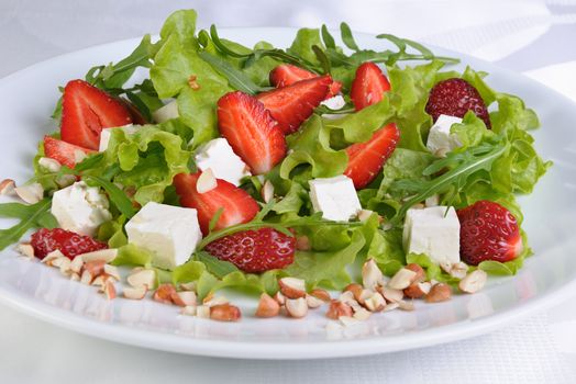 Salad of lettuce, arugula, strawberries, feta cheese and peanuts
