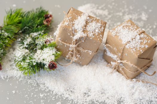 gift boxes and spruce twigs in snow. Christmas decor
