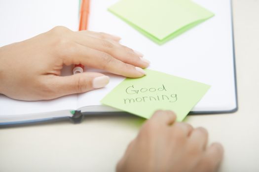 Hands holding sticky note with Good morning text