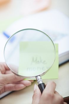 Woman looking through magnifying glass to the text