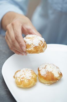 Woman eating eclairs at home. Vertical photos