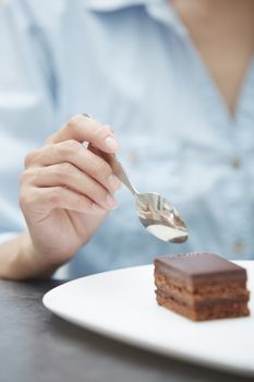 Hand of woman eating chocolate cake 