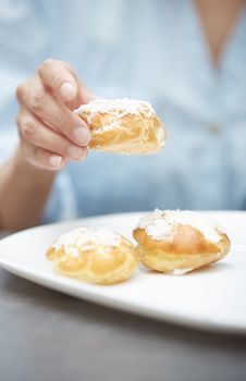 Woman eating eclairs at home. Vertical photos