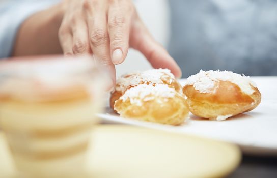 Woman taking eclairs from a plate