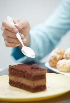 Hand of woman eating chocolate cake