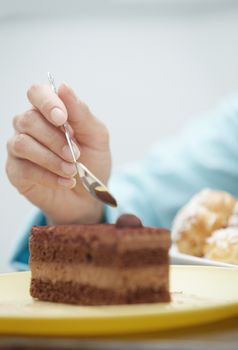 Hand of woman eating chocolate cake