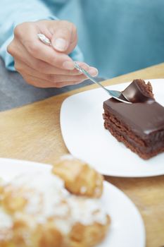 Hand of woman eating chocolate cake