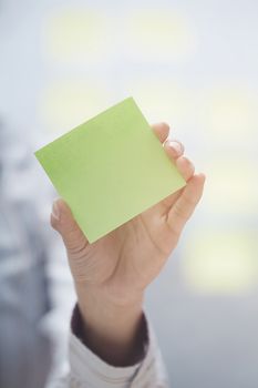 Woman holding sticky note with emplty space