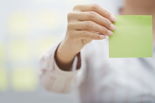 Woman holding sticky note with empty space