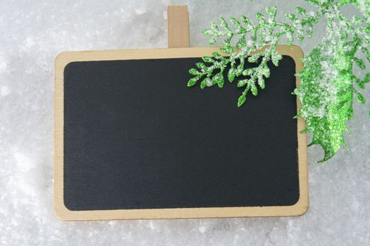 Blank blackboard on snow with Christmas decoration