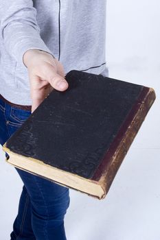 Female hand holding an old book on a white background