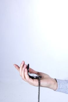 Pocket watch in a female hand on a white background