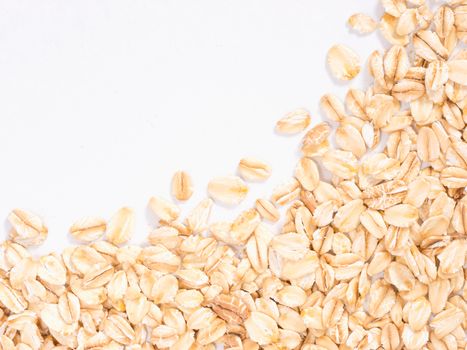 raw oatmeal on white background with copy space. Isolated one edge. Top view or flat lay.