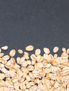 raw oatmeal on gray background with copy space. Isolated one edge. Top view or flat lay.