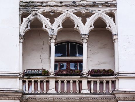 Antique balcony in the Gothic style on a building facade.