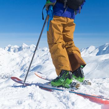 Freeride skier on the top of the mountain. Extreme winter freeride. Amazing landscape of snowy Alp mountains in the background. Vogel, Slovenia.