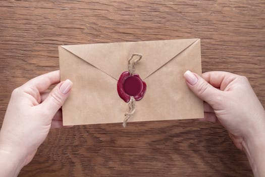 envelope in the hands on a wooden background