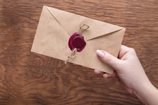 envelope in the hand on a wooden background