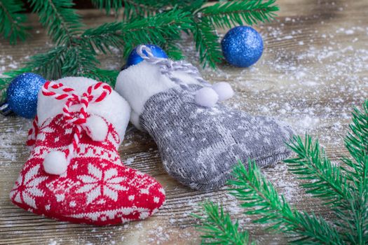 Christmas and New Year winter holiday snowbound composition of stockings on wooden space background with green fir tree branches and balls ornament